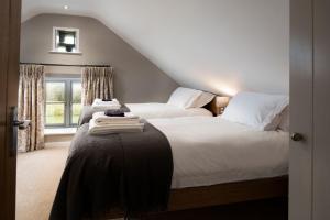 een slaapkamer met 2 bedden en een raam bij The Granary at Rothley East Shield in Longwitton