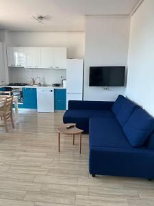 a living room with a blue couch and a kitchen at Anda2 in Mamaia