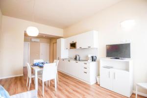 una cucina e una sala da pranzo con armadi bianchi e tavolo di Donatello Apartments by Firenze Prestige a Firenze