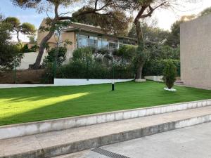 une maison avec une cour d'herbe verte dans l'établissement TarracoHomes, TH142 Villa Vista Alegre, à Tarragone