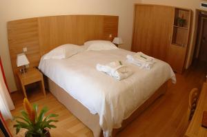 a bedroom with a bed with towels on it at Valis Resort Hotel in Volos