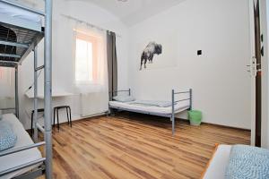 Pokój z 2 łóżkami piętrowymi i drewnianą podłogą w obiekcie Hostel Cinnamon w Krakowie