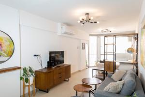 a living room with a couch and a tv at Impecable! Centro BA con pileta y parrilla 3 pax in Buenos Aires
