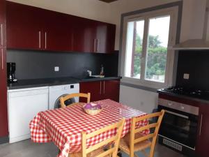 a kitchen with a table with a red and white checkered table cloth at maison 475 a parentis in Parentis-en-Born
