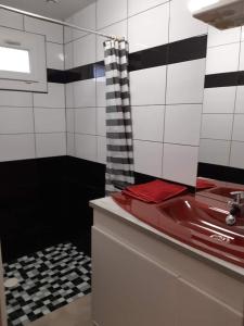 a bathroom with a red sink and black and white tiles at maison 475 a parentis in Parentis-en-Born