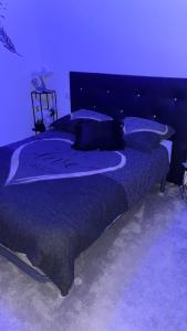 a blue bedroom with a large bed with pillows at Chez Chris et Gildas in Gilly-sur-Isère