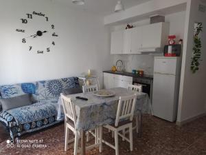 een woonkamer met een tafel en een keuken bij Villa Lilly in Pulsano