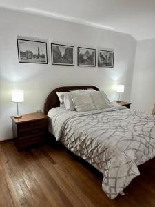 1 dormitorio con 1 cama y 3 cuadros en la pared en Apartamento cómodo y céntrico en Sucre