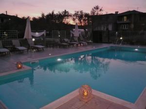 a large swimming pool with chairs and umbrellas at Hotel Avra in Lygia