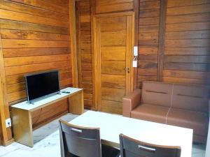 a room with a desk with a television and a table and chairs at VIA SPE - Pousada in Belo Horizonte