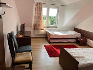 1 dormitorio con 2 camas, escritorio y silla en Zajazd Okalina, en Opatów