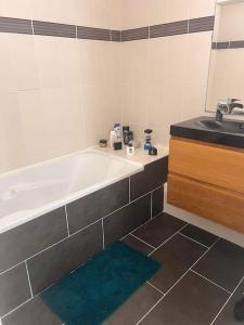 ein Badezimmer mit Badewanne und Waschbecken in der Unterkunft Maison à 800m des Remparts in Aigues-Mortes
