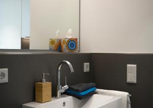 a bathroom with a sink and a mirror at Seven Hotel + Boardinghouse in Herzogenaurach