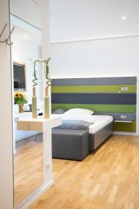 a bedroom with a bed and a table with a desk at Seven Hotel + Boardinghouse in Herzogenaurach
