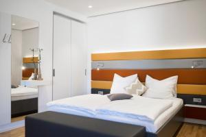 1 dormitorio con 1 cama grande y cabecero de madera en Seven Hotel + Boardinghouse en Herzogenaurach