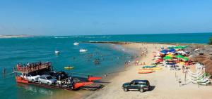 - un bateau sur la plage avec des personnes sur la plage dans l'établissement Hotel Tibau Lagoa, à Pipa
