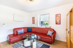 a living room with a red couch and a table at Ferienwohnung Geisbergblick in Seelbach