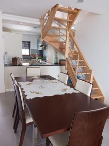 a dining room table with chairs and a staircase at Mar & Praia - Apartamento Pedra Ouro in Pedra Do Ouro
