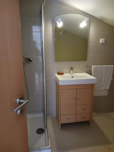 a bathroom with a sink and a shower with a mirror at Mar & Praia - Apartamento Pedra Ouro in Pedra Do Ouro