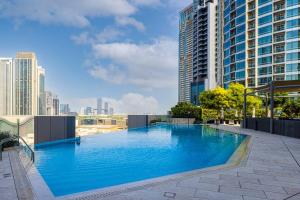 a large blue swimming pool on top of a building at Cozy 1Bed Connected to DubaiMall BurjKhalifa 5min in Dubai