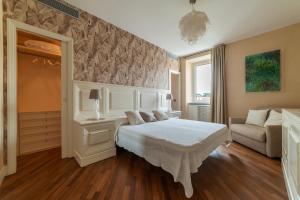 a bedroom with a white bed and a couch at Vista su San Pietro - la Venere su Roma Apartment in Rome