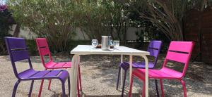 a table with four chairs and a table with wine glasses at Freisquéro in Bandol