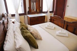 a bedroom with a bed with white and green pillows at Ca' Alle Gondolette in Venice