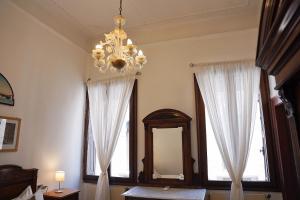 a room with a chandelier and two windows at Ca' Alle Gondolette in Venice