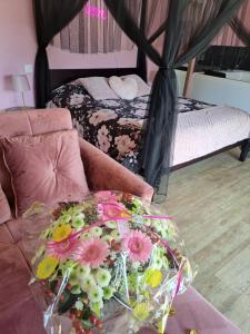 um quarto com um sofá com flores em La suite d'Élise avec jaccuzi em Grumesnil