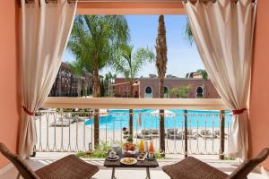 - une vue sur la piscine depuis le salon du complexe dans l'établissement Savoy Le Grand Hotel Marrakech, à Marrakech