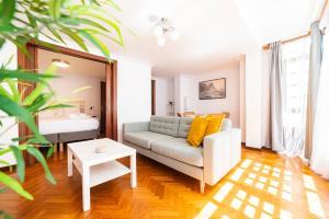 ein Wohnzimmer mit einem Sofa und einem Tisch in der Unterkunft Apartamento Carmiña in Puentedeume
