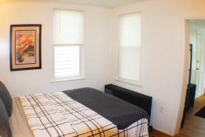 a bedroom with a bed and two windows at Urban Oasis - 3BR 2BA - City View- Private Parking in Pittsburgh +14 photos