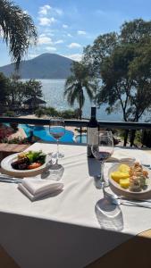 una mesa con dos platos de comida y copas de vino en Hotel Del Dique en Coronel Moldes