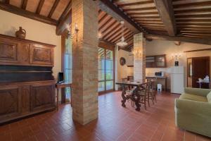 a large living room with a table and a kitchen at Fattorie Santo Pietro in San Gimignano