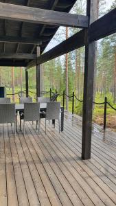Holiday home Villa Esteri في Pyhätunturi: فناء به طاولات وكراسي على سطح خشبي