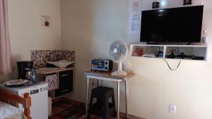 Habitación con TV y mesa con ventilador. en Chalés Mimar Lumiar Suítes individuais en Lumiar