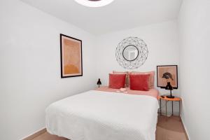 una camera da letto con un grande letto bianco con cuscini rossi di Appartment Patricia a Orba