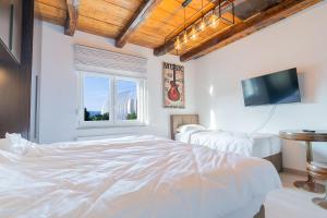 a white bedroom with a large bed and a window at Arena Rooms Zagreb in Zagreb