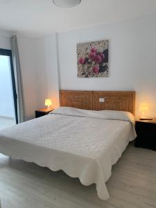 a bedroom with a large bed with two tables and two lamps at Vita Ideale in Arguineguín +11 photos