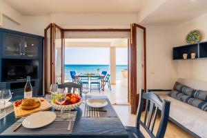 a dining room and living room with a view of the ocean at Le Terrazze di Apollo - Case Tilotta in Marinella di Selinunte