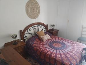 ein Schlafzimmer mit einem Bett mit einer bunten Bettdecke in der Unterkunft Apartamento en Serra con preciosas vistas. in Serra