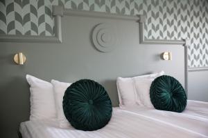 a bed with two green pillows on top of it at Säröhus Hotel, Conference & Spa in Särö +41 photos