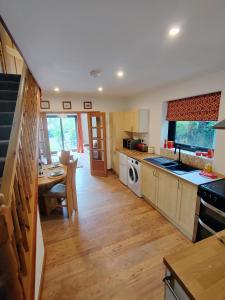 a kitchen with a table and a dining room at Bryn Mynach Annex in Barmouth