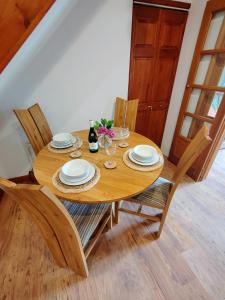 a wooden table with chairs and a bottle of wine at Bryn Mynach Annex in Barmouth