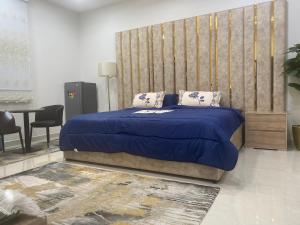 a bedroom with a bed with a blue blanket at التوفيق للوحدات السكنية T1 in Al Ahsa