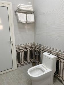 a white bathroom with a toilet and towels at التوفيق للوحدات السكنية T1 in Al Ahsa