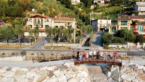 eine Gruppe von Menschen, die eine Brücke über einen Fluss überqueren in der Unterkunft Hotel Veronesi in Brenzone sul Garda