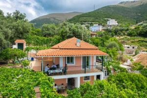 a house with a balcony with mountains in the background at Gurra room's in Lukovë