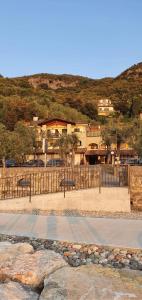 einen Park mit Bänken und einem Zaun und einem Gebäude in der Unterkunft Hotel Veronesi in Brenzone sul Garda