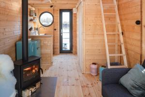 Wunderschönes Hausboot AGATHE في هامبورغ: غرفة معيشة مع موقد خشب في منزل صغير
